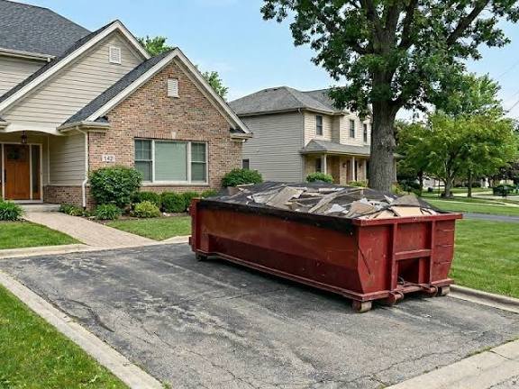 20-yard roll-off dumpster with tarped remodel debris on a Jackpot driveway