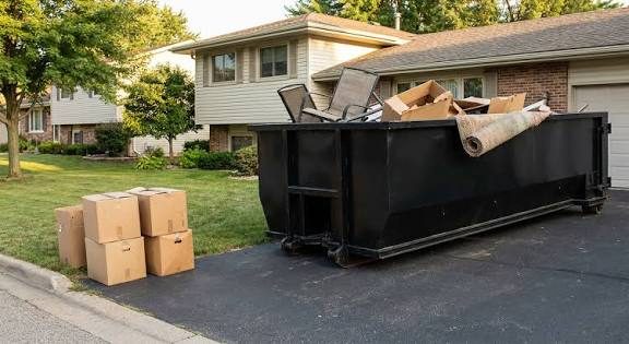 Black roll-off dumpster filled with moving boxes and household junk in Laughlin, NV